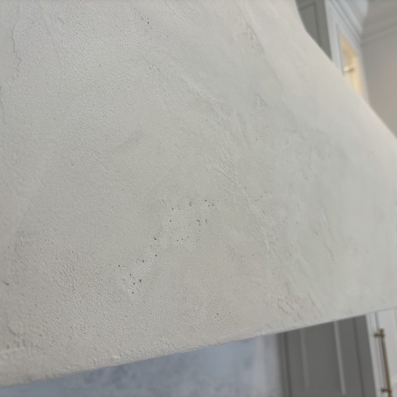 Close-up of the subtle texture and mottling on the white range hood