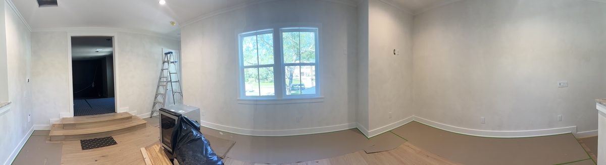 Panoramic view of an upstairs room with soft white walls, a window, and a raised landing with steps